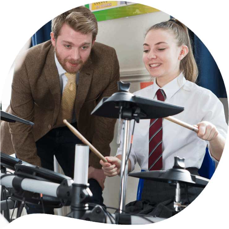 Profesor enseñando a un alumna a tocar la batería